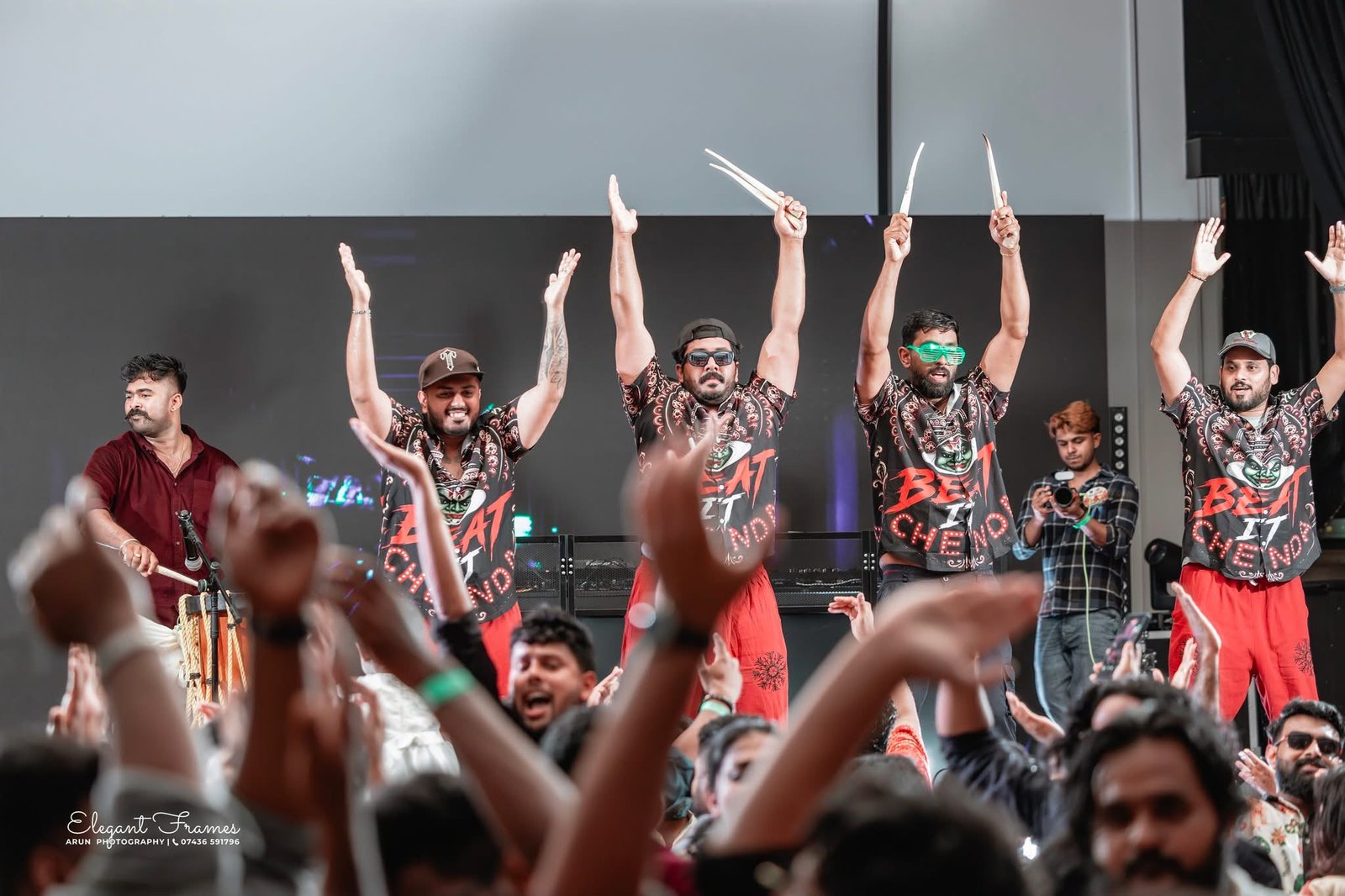 Beat It Chenda drummers and audience members celebrating with their hands raised